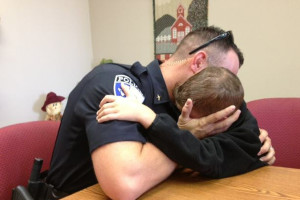 Police Chief James Waters hugs his son after a prayer meeting with law enforcement personnel.