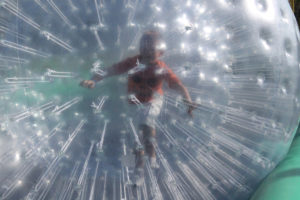 Hayden Brister rolls down the course in a hamster ball while wearing a spooky Halloween shirt.